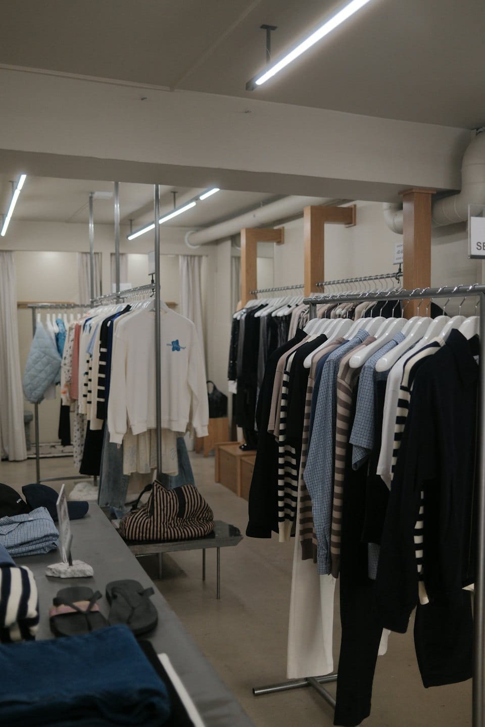 Percheros con ropa y accesorios expuestos en una boutique moderna.