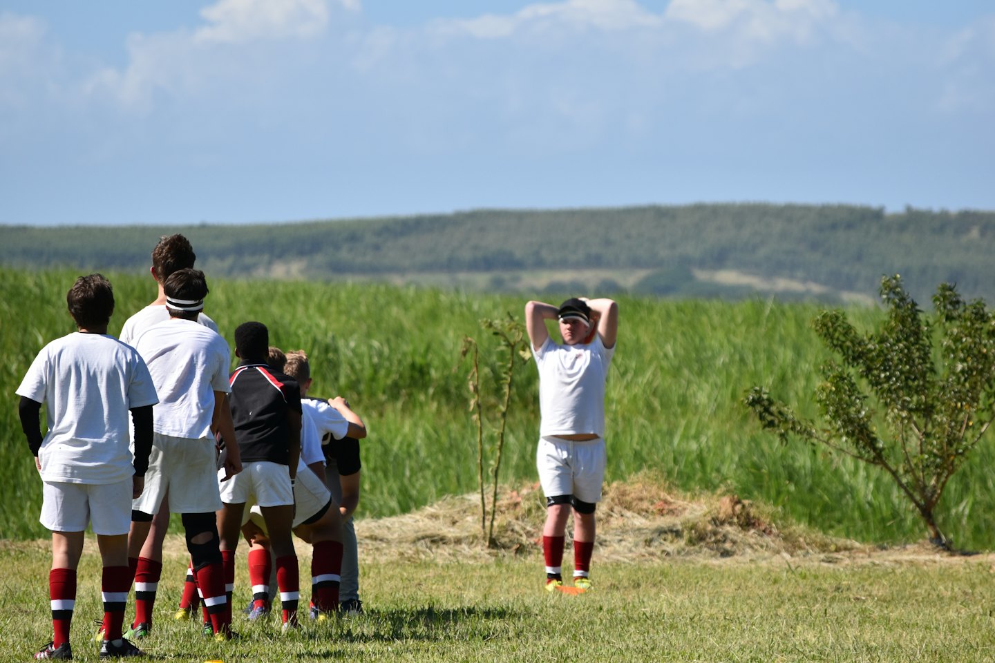Atletas uniformados en un campo de práctica.