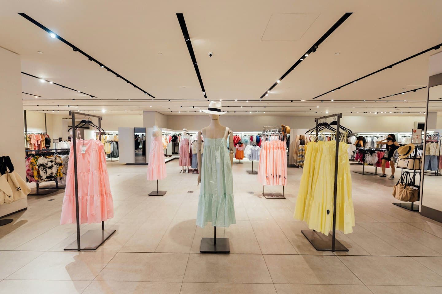 Maniquíes exhiben vestidos de verano en una tienda de ropa moderna.